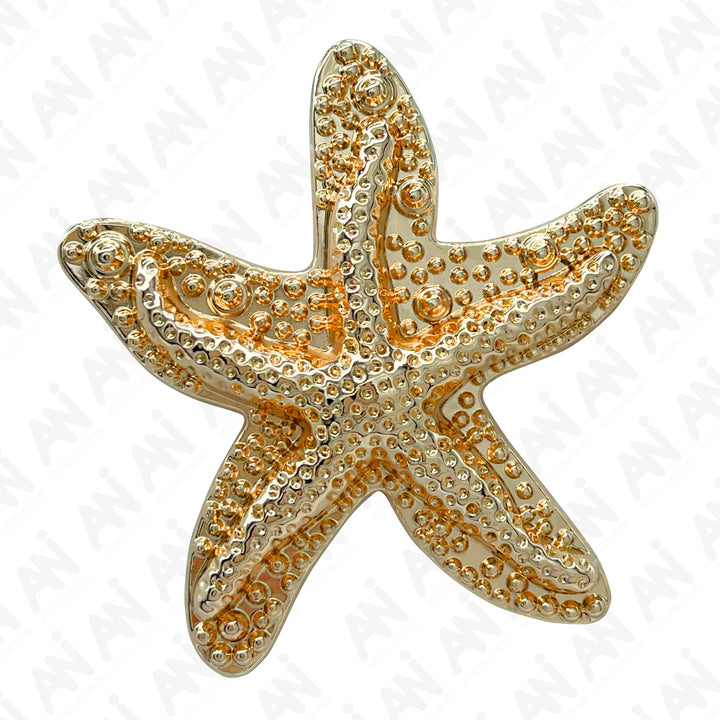 A gold-colored metal brooch in the shape of a starfish, featuring intricate details and designs.