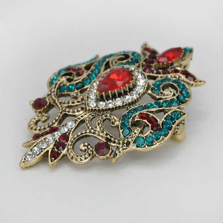 ANI Accessories antique brooch for women from an angle showing the raised red and teal stones 