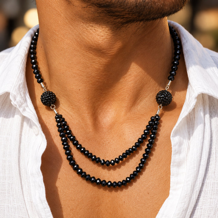 ANI Accessories black beaded necklace for men worn over a white shirt 