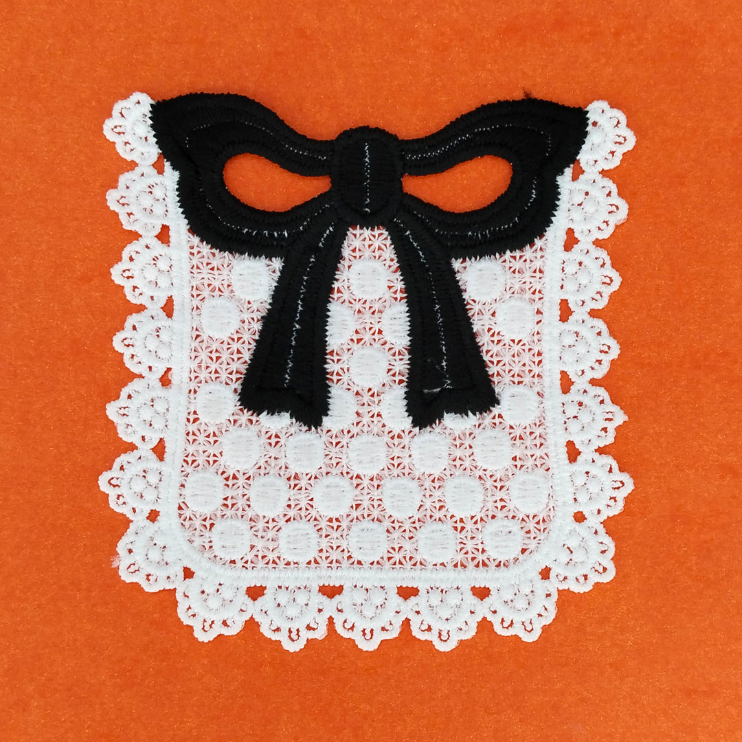 ANI Accessories close view of the black bow and white dotted pocket patch on orange