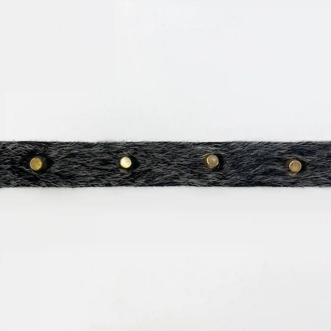ANI Accessories black fur strip for clothes with gold metal studs laid flat with white color background 