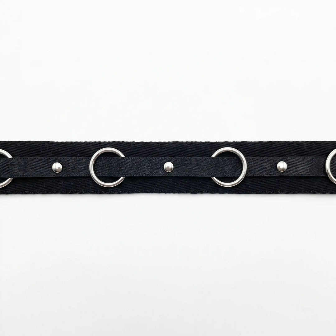 ANI Accessories black herringbone tape with silver O-rings laid flat on white Background 