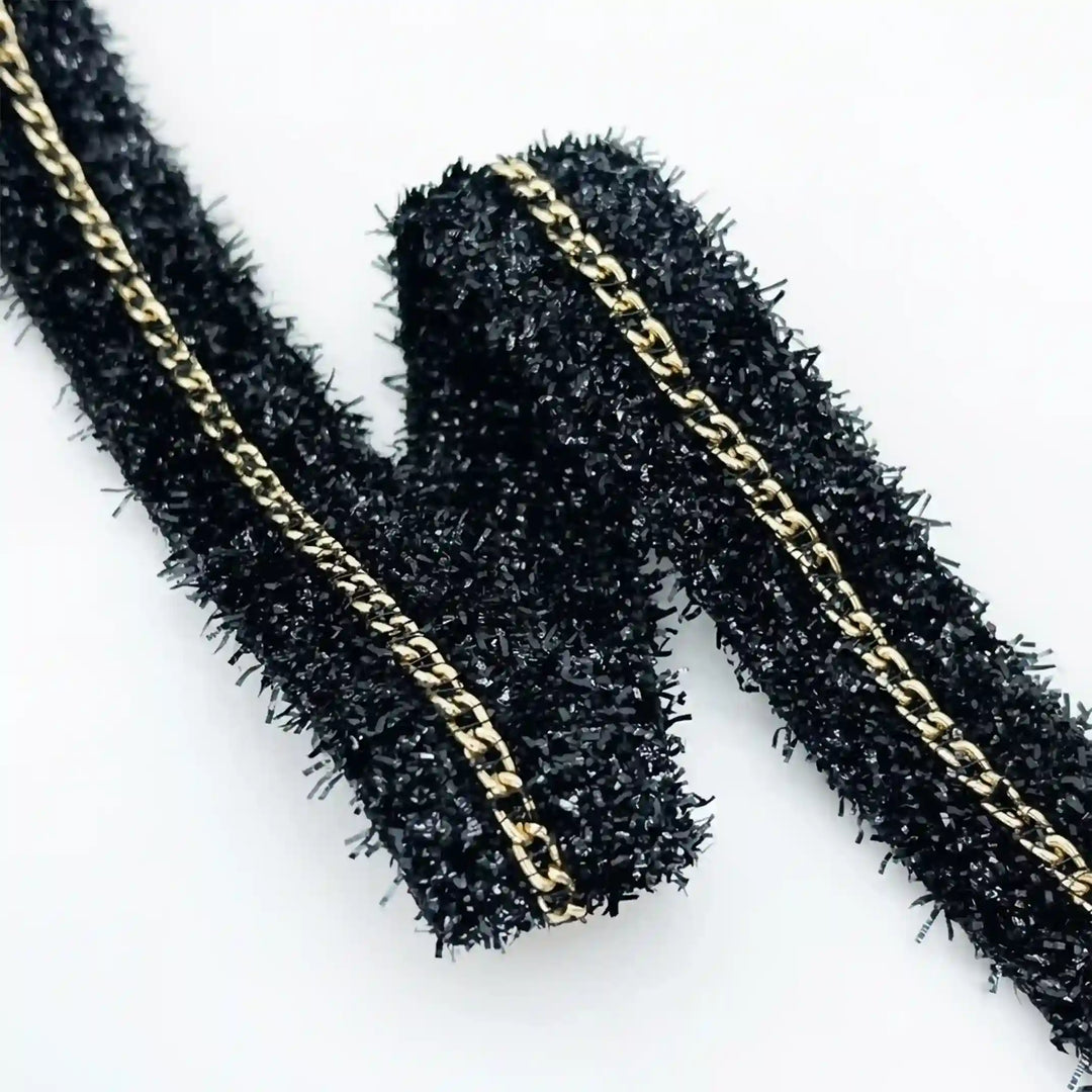 ANI Accessories close-up of shiny black lurex strands and gold chain with white color background 