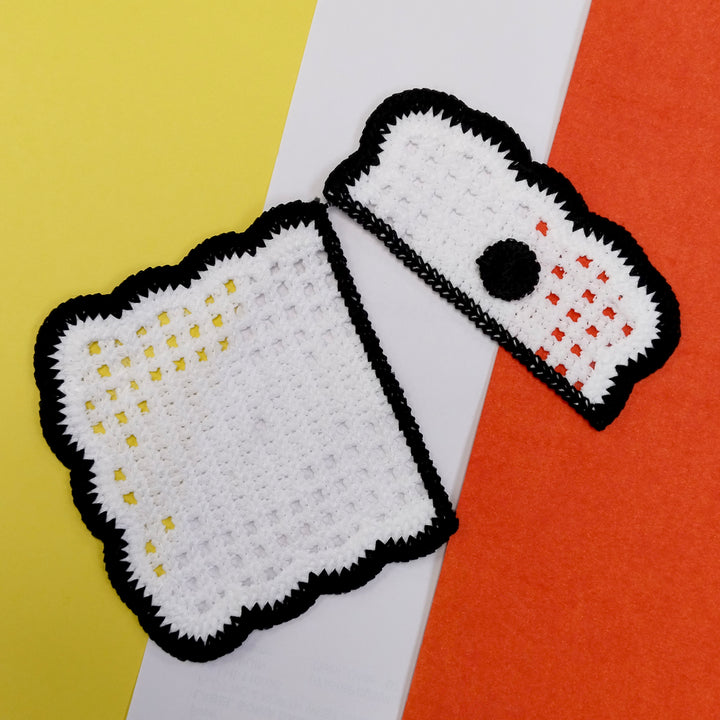 ANI Accessories black and white sew-on pocket patch, two pieces laid at an angle on yellow and orange 