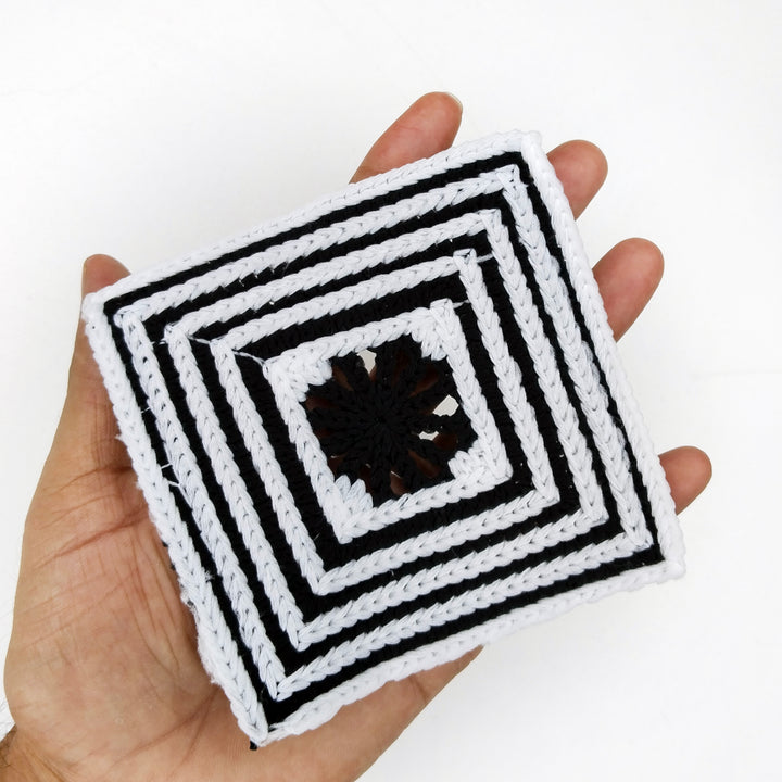ANI Accessories black and white square patch held in an open palm to show its 4 inch size 