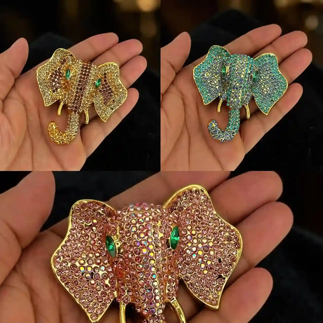 ANI Accessories crystal elephant brooches in pink, green and gold held in hand 