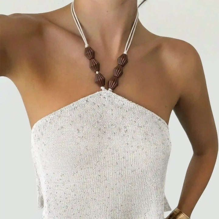 ANI Accessories dark brown melon cord end beads strung on the cream halter neck ties of a white sequin knit halter top 
with white Color Background 