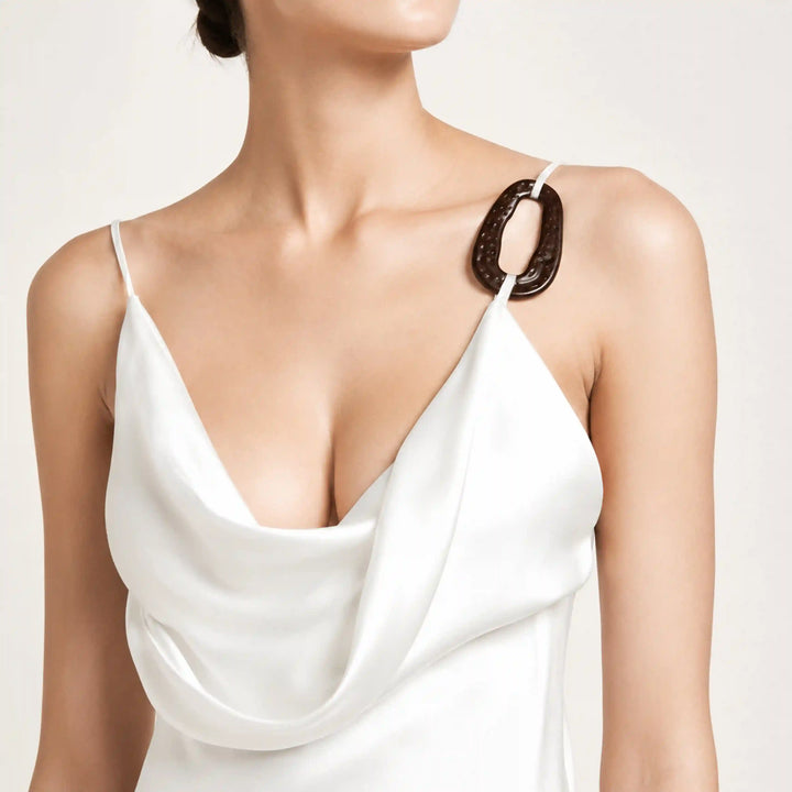 ANI Accessories dark brown oval ring buckle used as a strap connector on a white satin cowl-neck camisole with white color background 