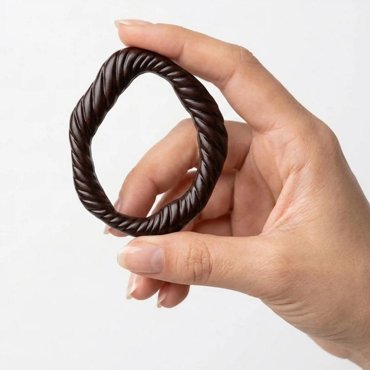 ANI Accessories dark brown twisted rope ring buckle held upright between fingers to show real size, on white background 
