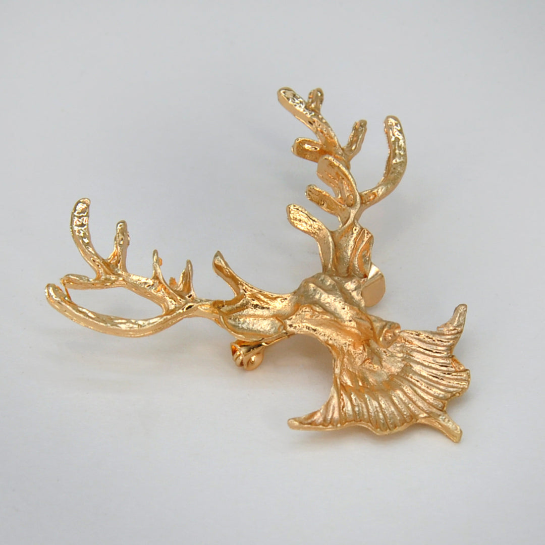 Side view of the gold deer head brooch showing the textured antlers with white color background 