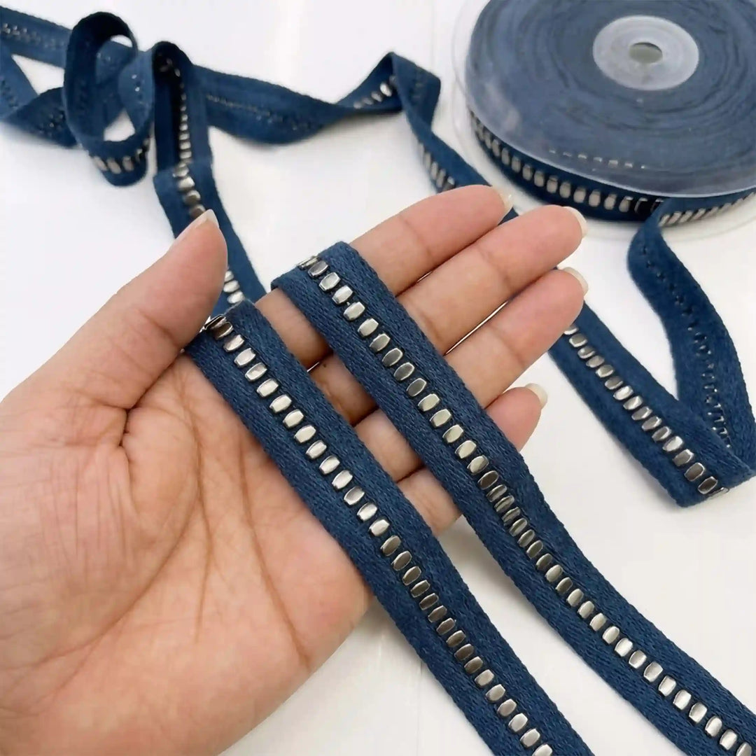ANI Accessories denim ribbon trim for jeans held in hand next to the roll 