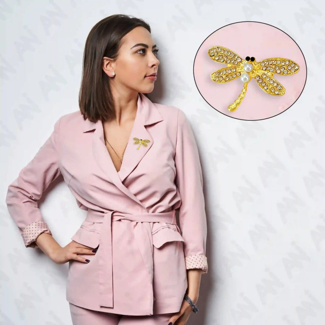 Elegant dragonfly pearl brooch with a golden design, worn on a stylish pink blazer