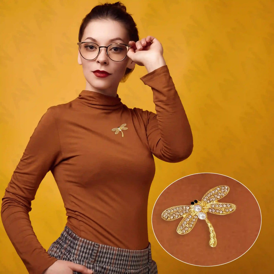 Elegant dragonfly pearl brooch designed by Ani Accessories, showcased on a model wearing a brown turtleneck