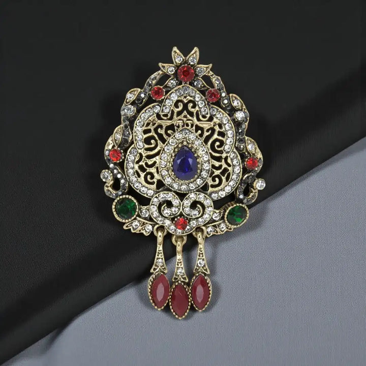 ANI Accessories Edwardian style brooch in antique gold with blue centre stone and red drops 