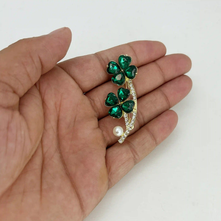 ANI Accessories emerald green clover brooch held in hand to show its size 