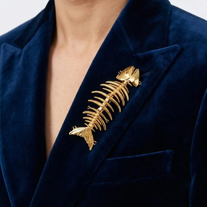 ANI Accessories gold fish skeleton brooch pinned on a blue velvet blazer 