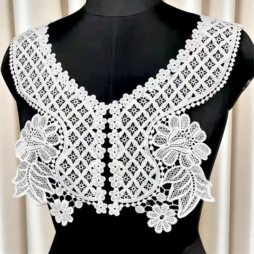 White floral V neckline patch with diamond grid and large flower motifs on a black mannequin 