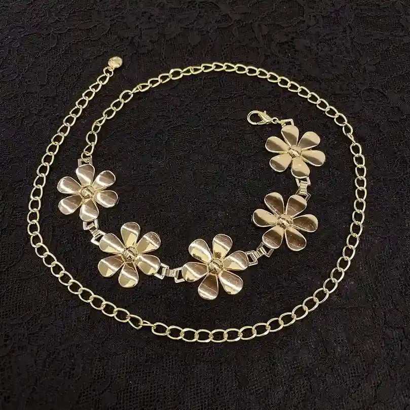 ANI Accessories gold daisy chain belt laid flat on black fabric 