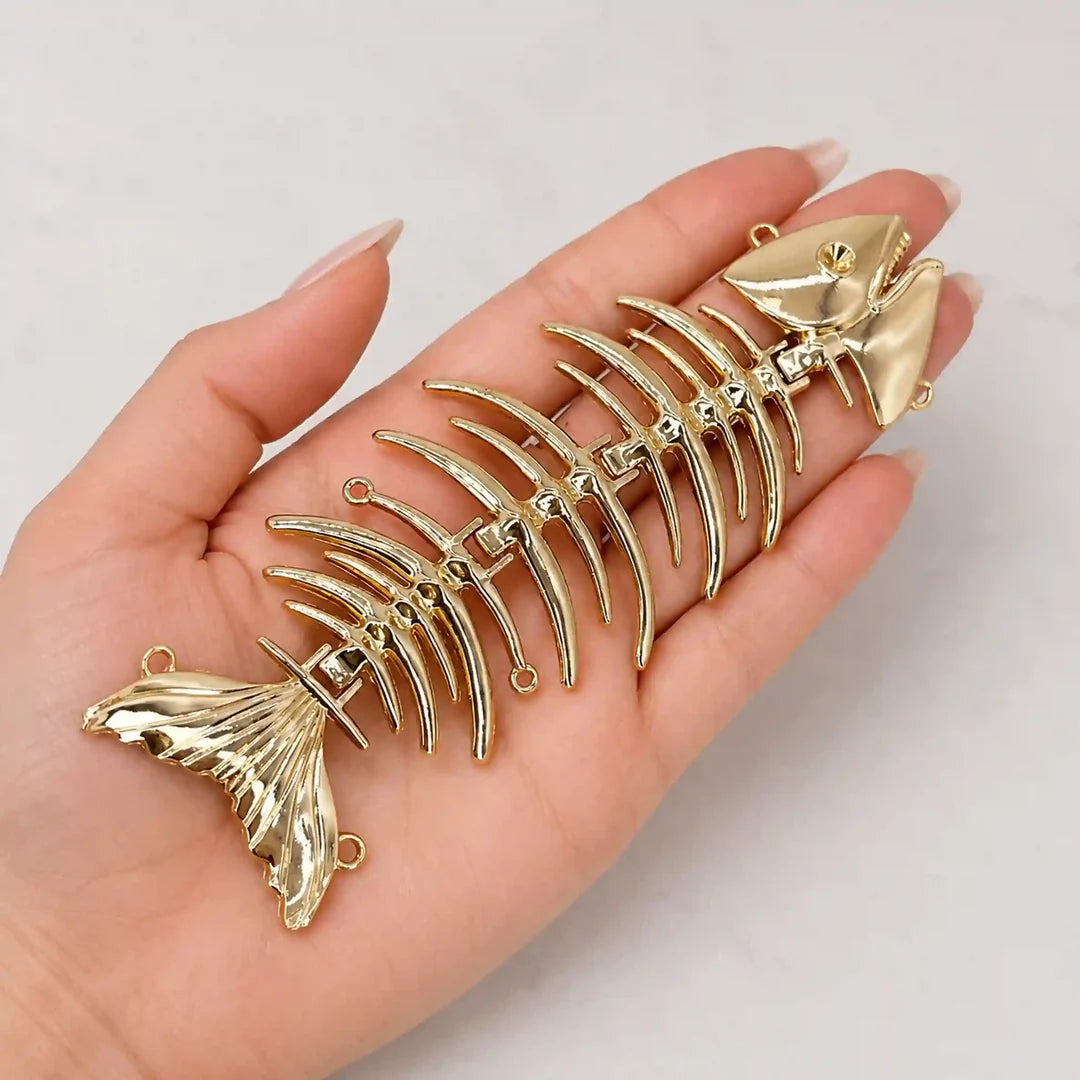ANI Accessories gold fish skeleton brooch held in hand to show its large size 