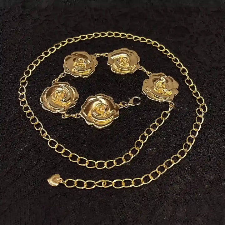 ANI Accessories gold flower chain belt laid in a circle on black fabric 