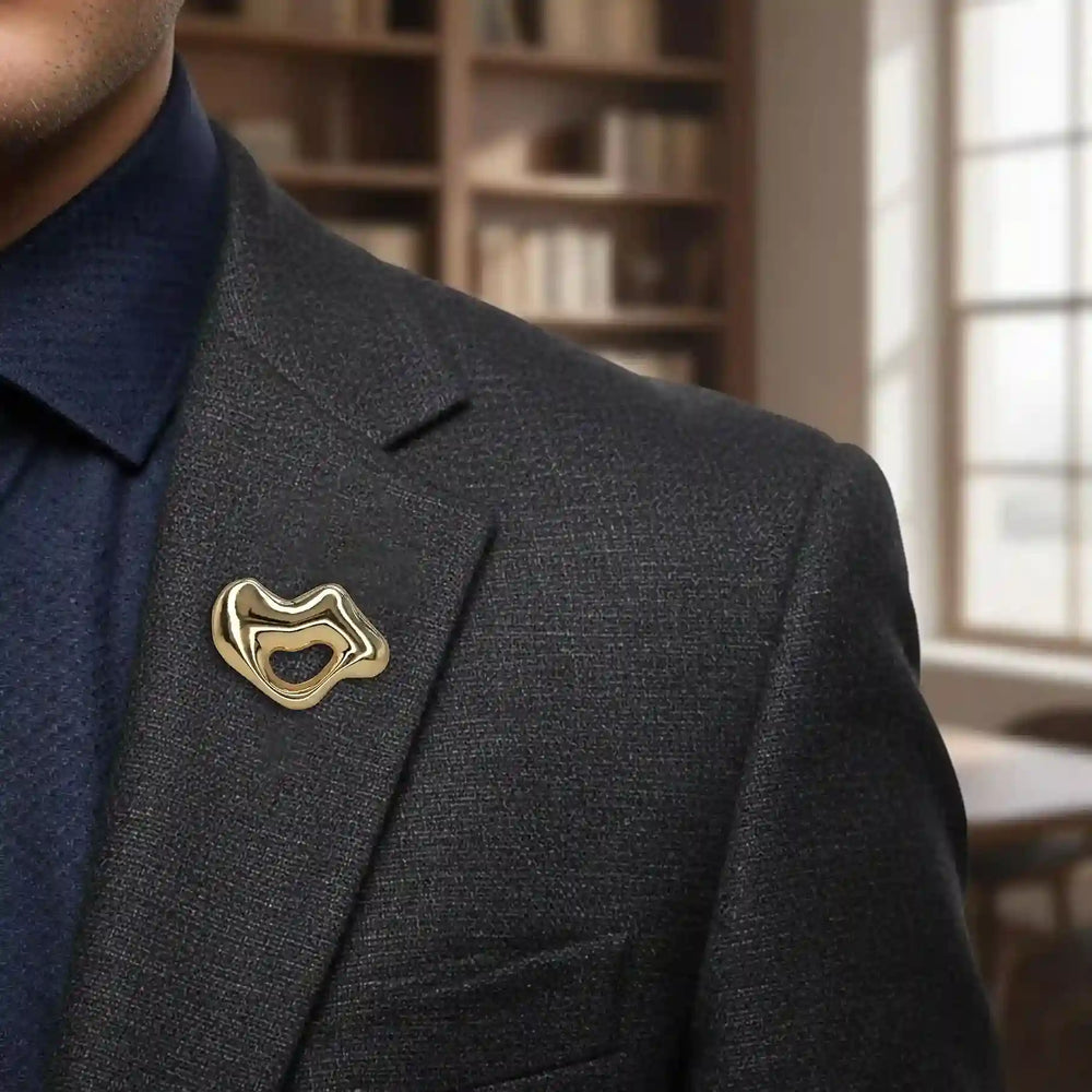 ANI Accessories gold lips brooch pinned on the lapel of a dark navy blazer 