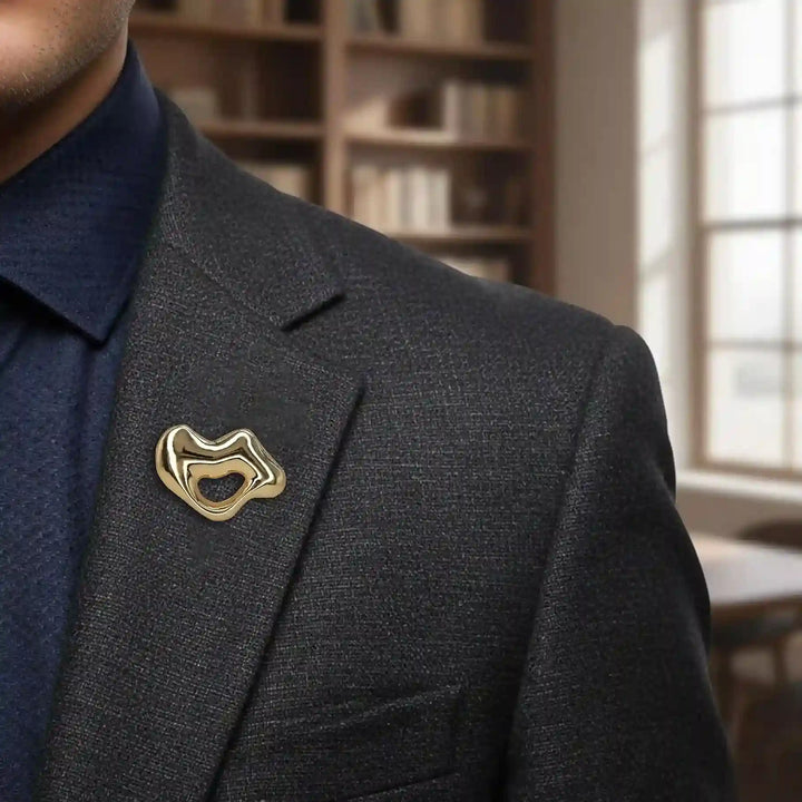 ANI Accessories gold lips brooch pinned on the lapel of a dark navy blazer 