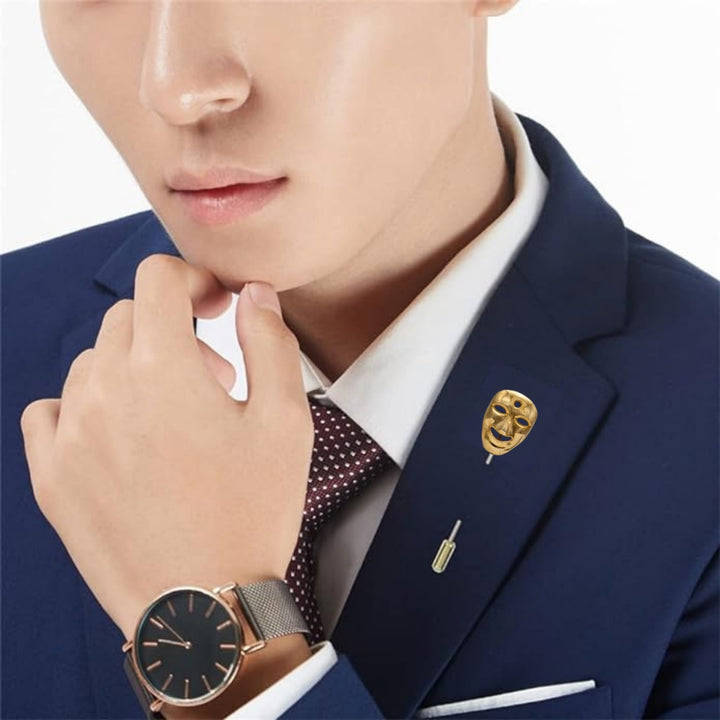 Elegant gold mask lapel pin styled on a suit jacket for a sophisticated look