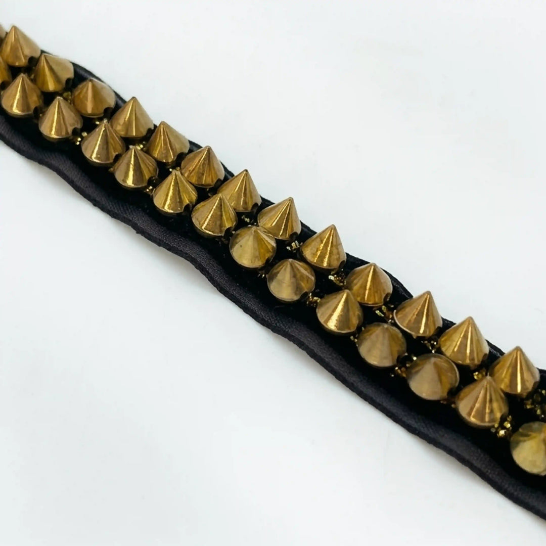 ANI Accessories close-up of gold spike trim showing cone-shaped metal studs with white color Background 
