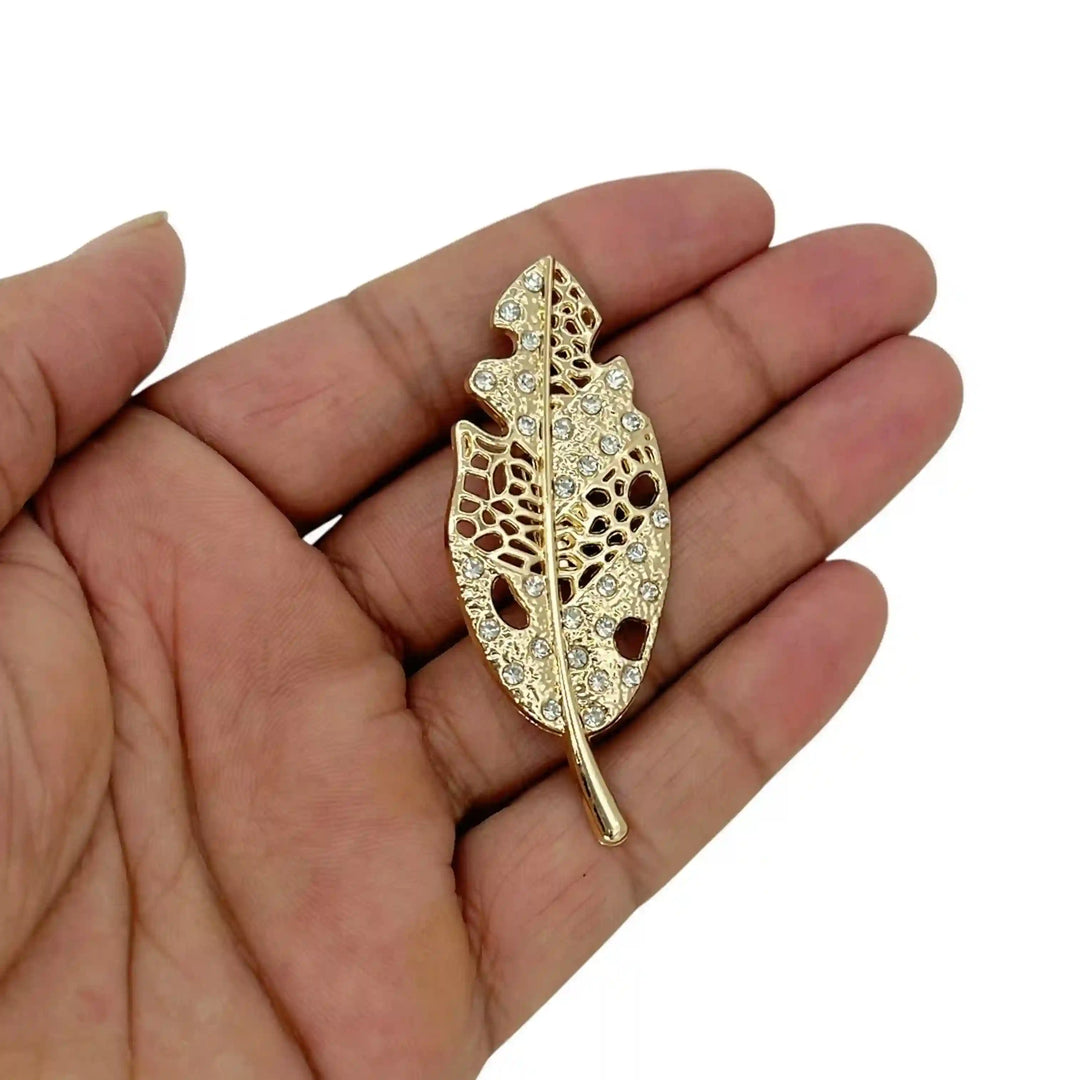 ANI Accessories golden leaf brooch pin held in hand to show its slim size with white color background 