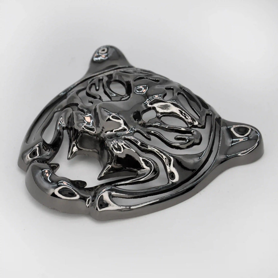 Side view of the gunmetal tiger face emblem showing the laser-cut stripes with white color background 