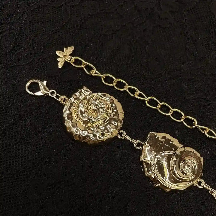 ANI Accessories close-up of a hammered gold seashell and lobster clasp 