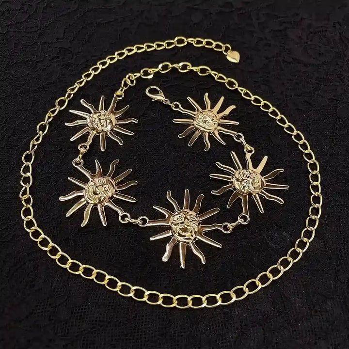ANI Accessories metal sun chain belt with five sun faces laid on black fabric 