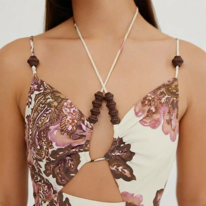 ANI Accessories mini dark brown fluted cord end beads strung on the halter ties and straps of a cream paisley print cut-out top White Background