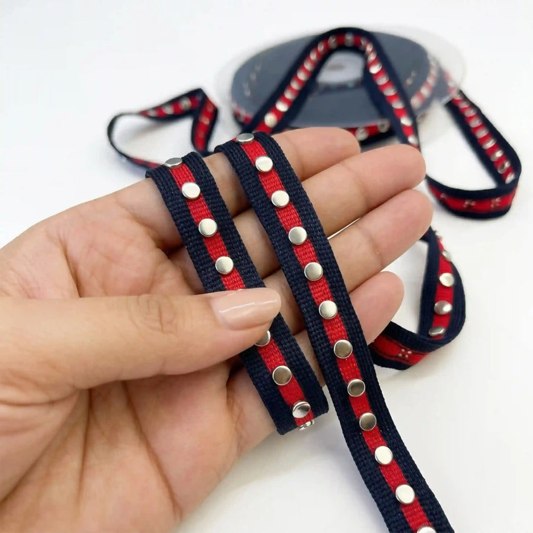ANI Accessories navy and red striped ribbon with silver studs held in hand with white color background 