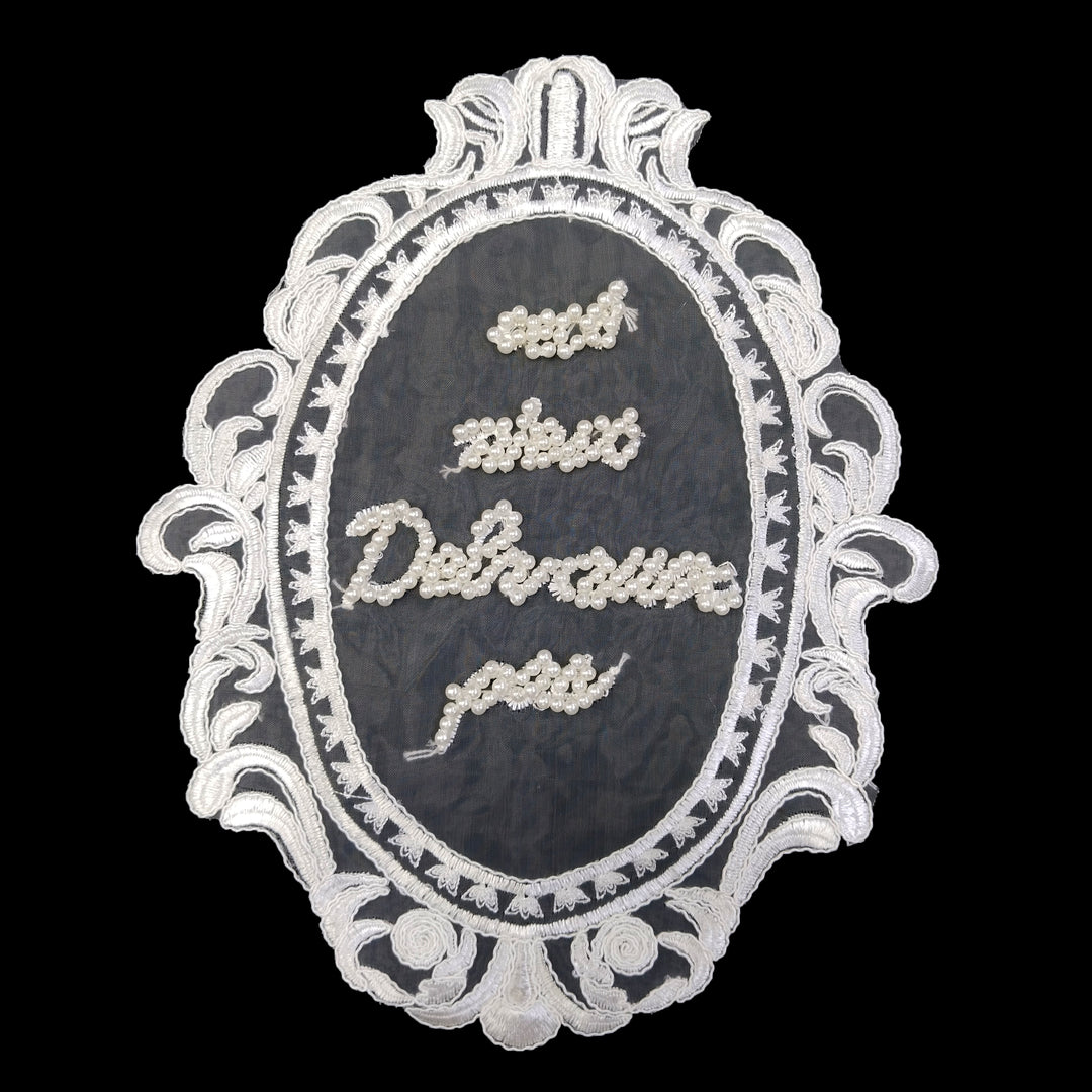 ANI Accessories white oval frame embroidered patch with pearl-beaded lettering, on black background 