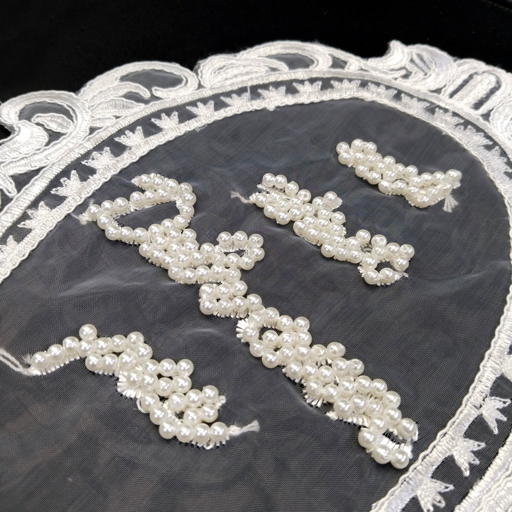 ANI Accessories close-up of pearl bead lettering on sheer net inside an embroidered oval frame 