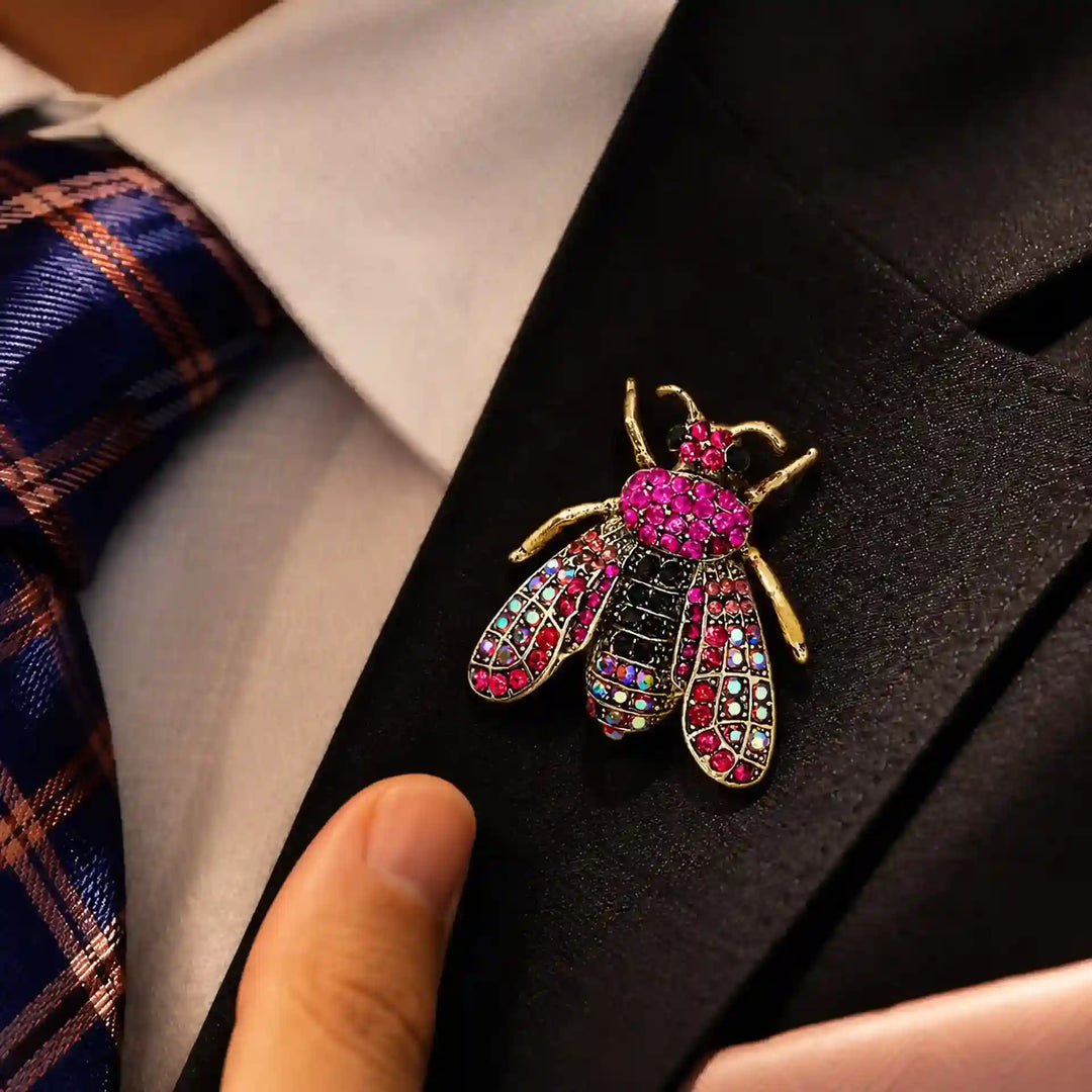 ANI Accessories pink honeybee crystal brooch on the lapel of a man's navy blazer 