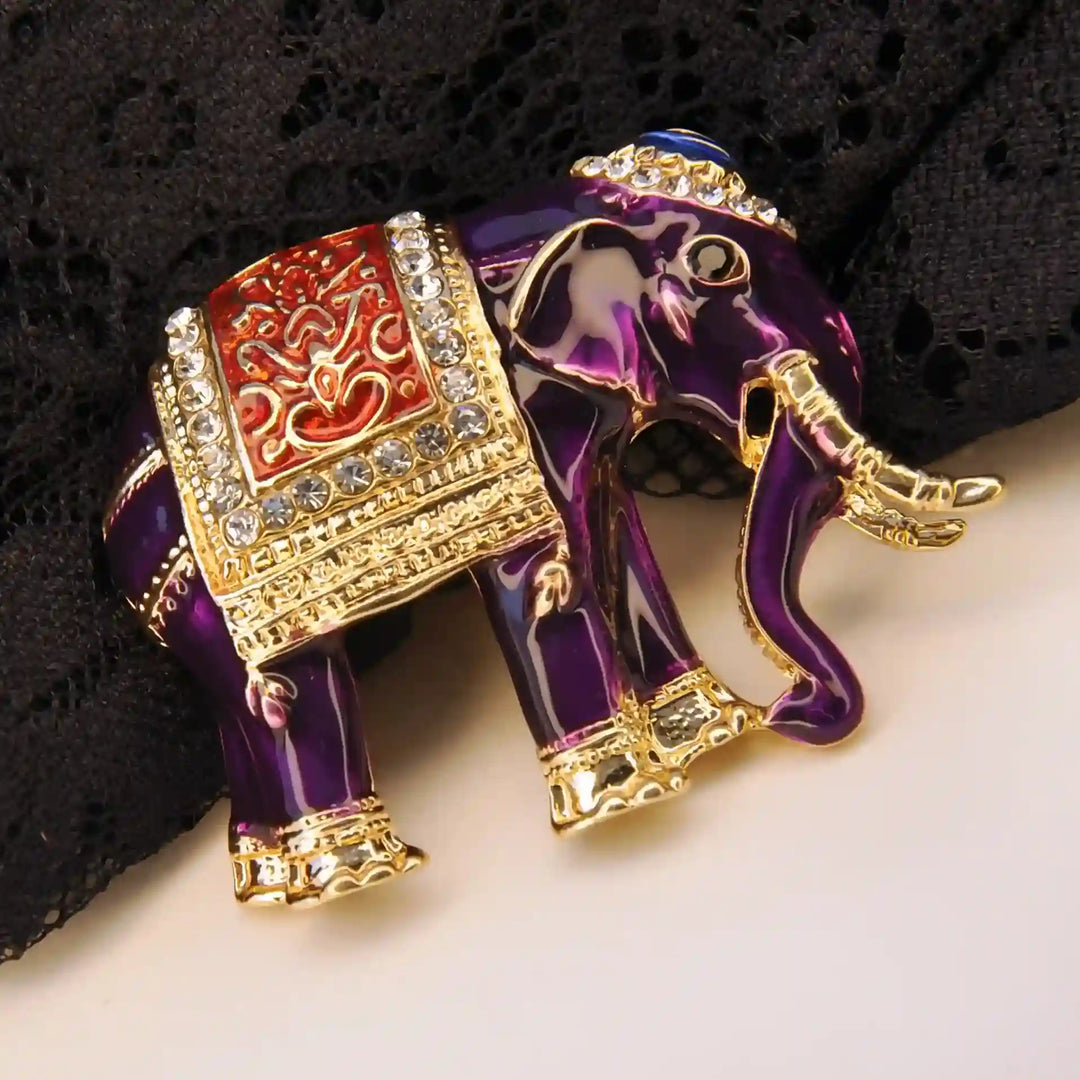 Close-up of a purple elephant brooch showing the glossy enamel and saddle cloth 
