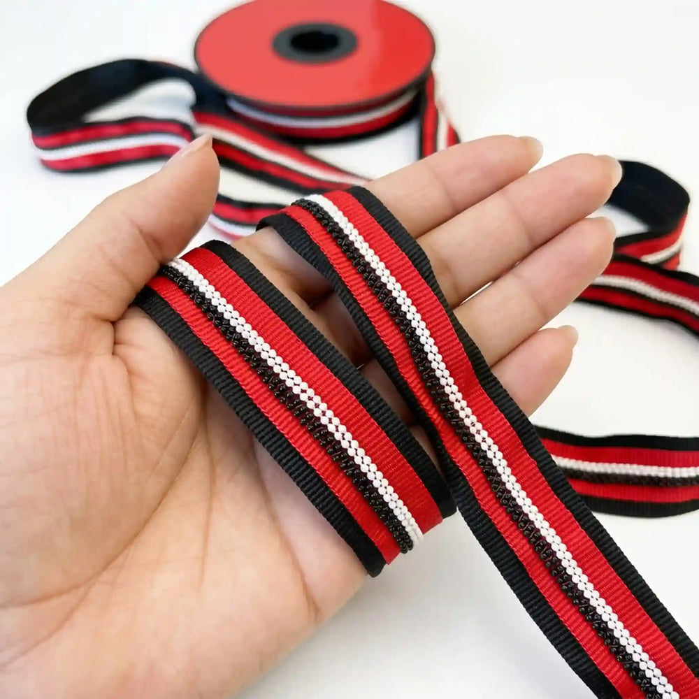 ANI Accessories red and black beaded lace ribbon, 2.5 cm, held in hand with white color background 