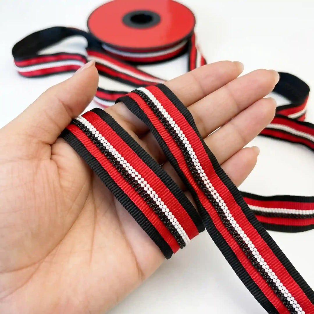 ANI Accessories red and black beaded lace ribbon, 2.5 cm, held in hand with white color background 