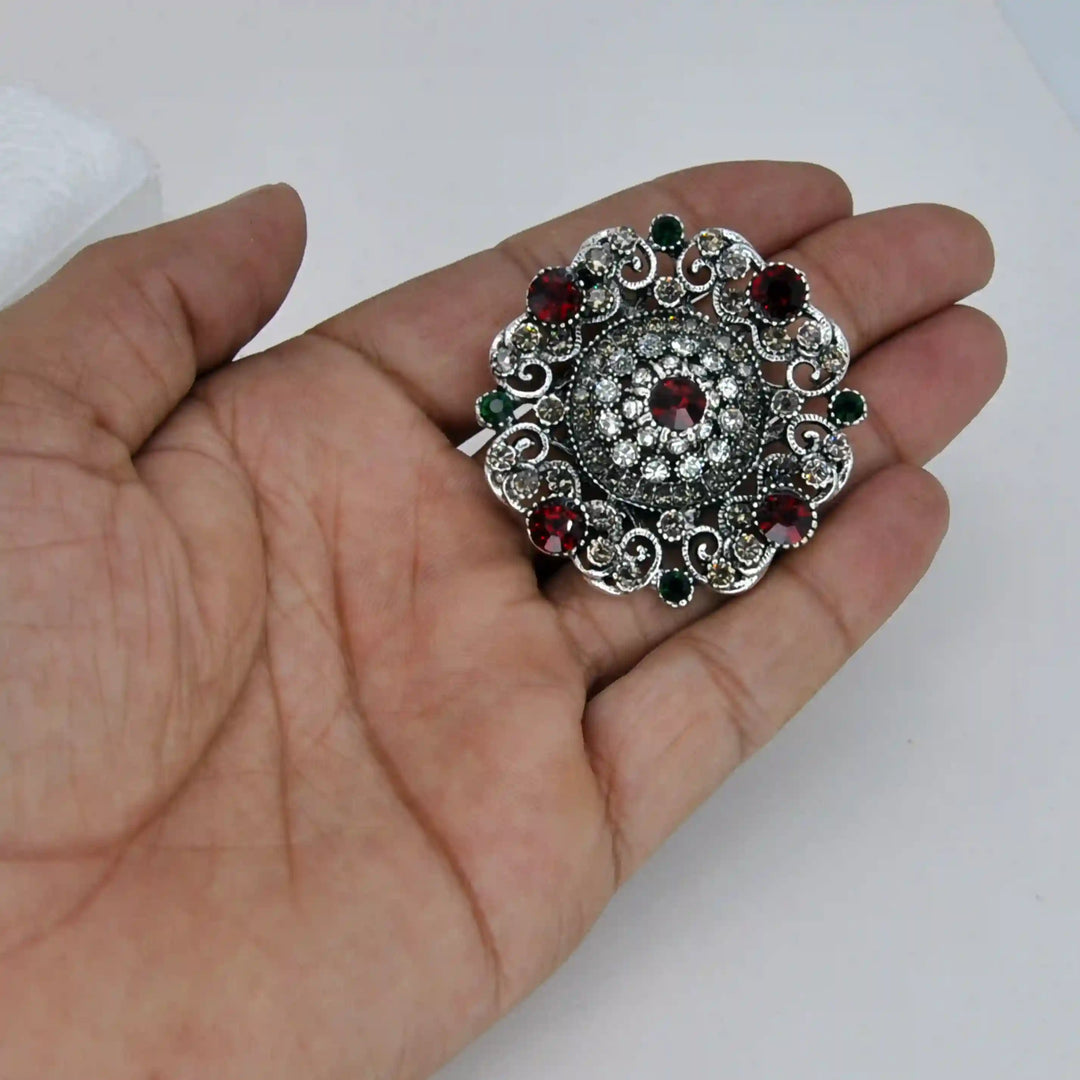 ANI Accessories round crystal brooch held in hand to show its size 