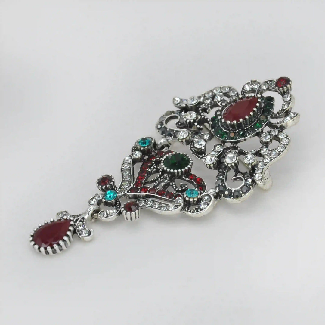 ANI Accessories royal heirloom brooch from an angle showing the raised stones and linked sections