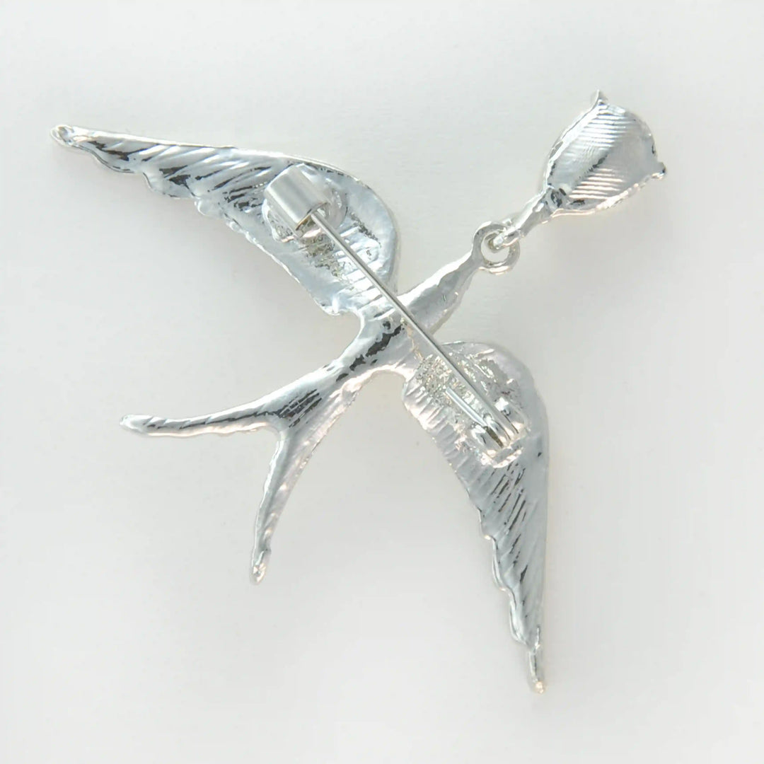 Side view of the silver bird brooch showing the engraved feathered wings 