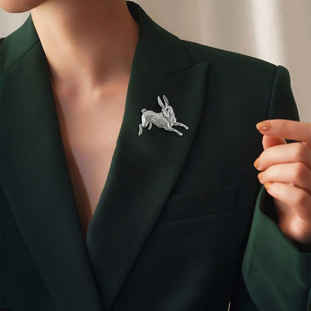 ANI Accessories silver bunny brooch pinned on the lapel of a dark green blazer 