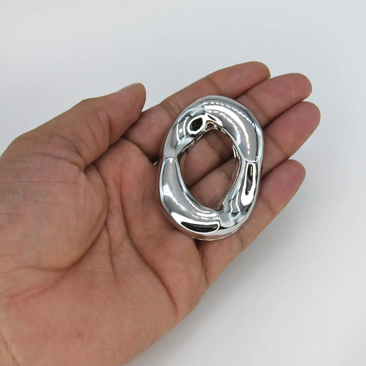ANI Accessories silver oval brooch held in hand to show its size 
