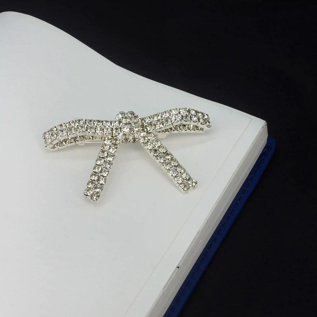 Sparkling Rhinestone Metal Brooches for Women displayed on a notebook cover for stylish accessory ideas