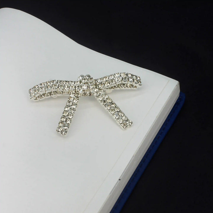 Sparkling Rhinestone Metal Brooches for Women displayed on a notebook cover for stylish accessory ideas