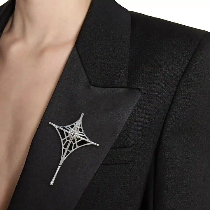 ANI Accessories spider web lapel pin worn on the lapel of a black blazer 