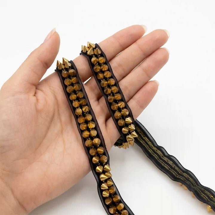 ANI Accessories studded lace held in hand to show the two rows of gold studs with white color Background 