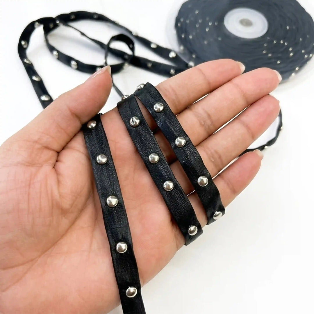 ANI Accessories studded leather strip held in hand next to the roll with white color background 